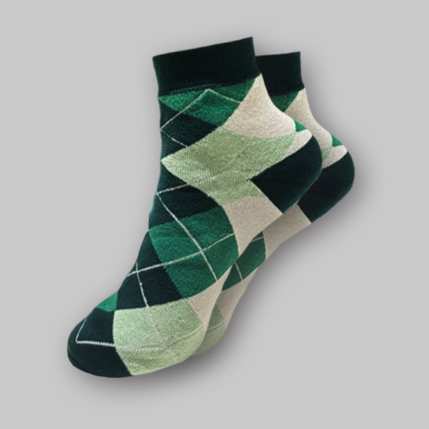 Green and beige argyle patterned socks on a gray background